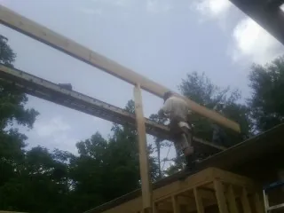 Carpenter setting a ridge beam over a new addition frame — Ice Dam Removal by Roofing Brothers in Oakton