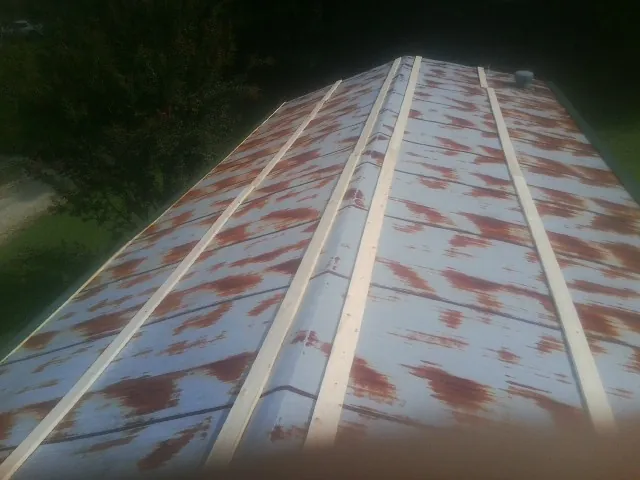 Rusted metal roof panels with new wood purlins before replacement — Storm Damage Roof Repair in Oakton by Roofing Brothers
