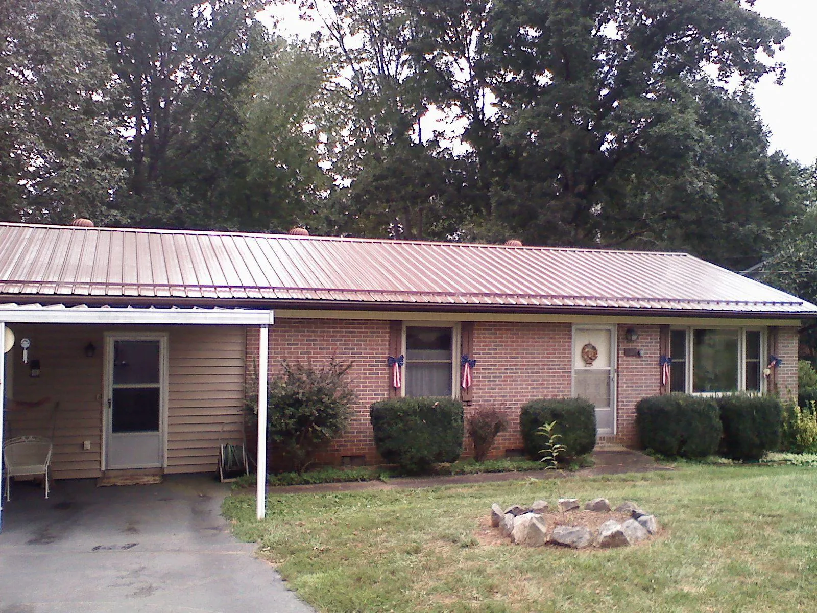 Bronze metal roof and carport on a brick ranch home — Roof Repair work by our crew in Oakton