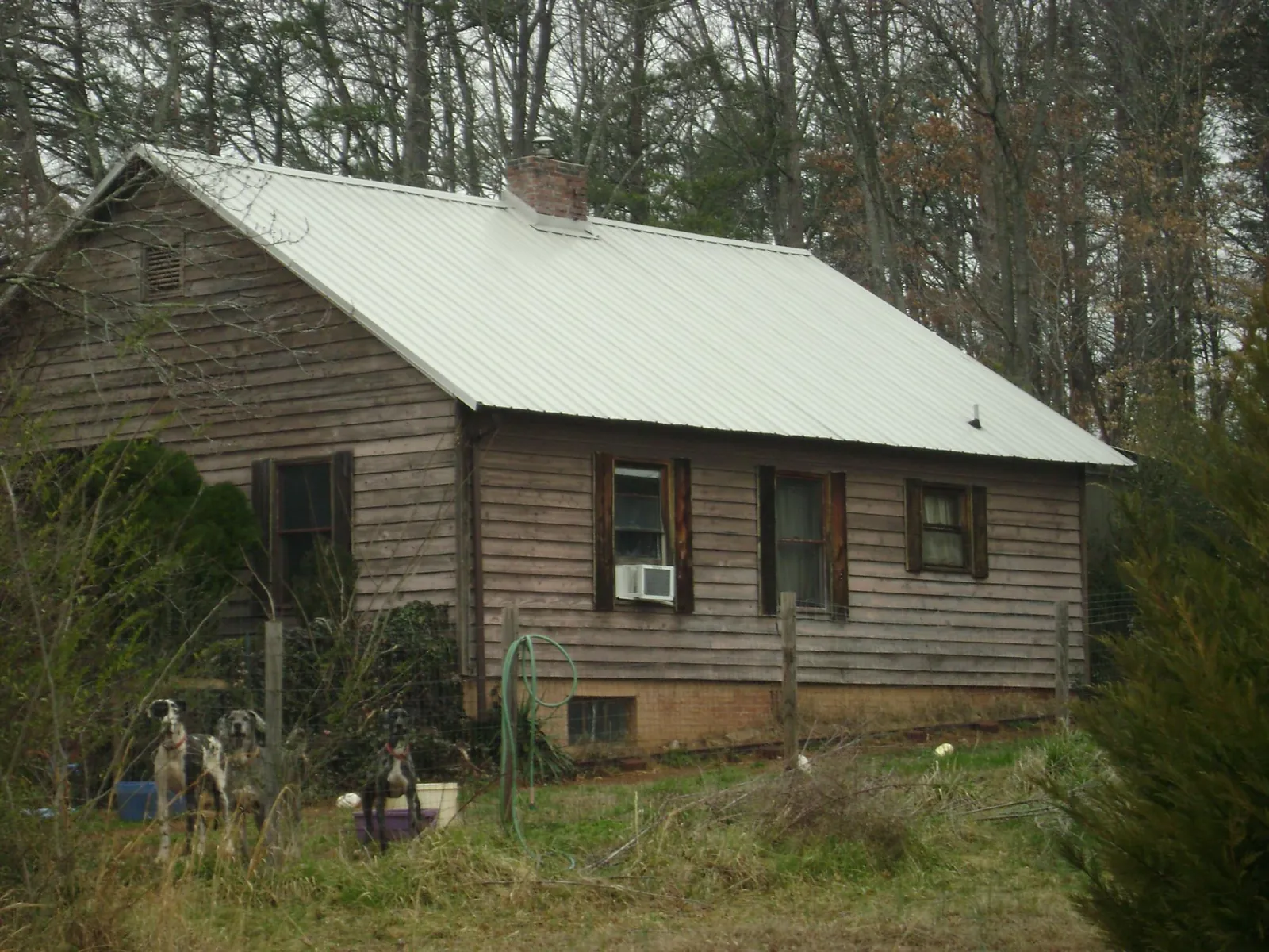White metal roof on an old wood sided farmhouse, from a Metal Roof Installation job in Oakton